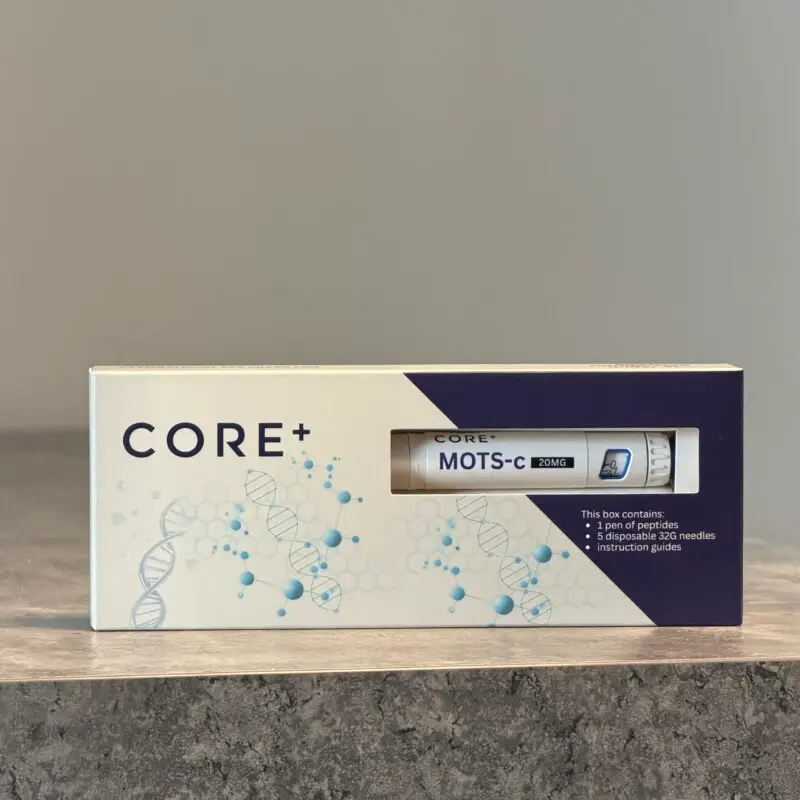 CORE+ box with blue splash graphics and a MOTS-C device image on a purple diagonal panel, placed on a wooden surface.